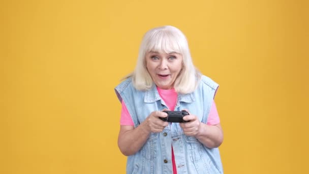 Funky anciana dama jugando video juego puño arriba ganar aislado brillo color fondo — Vídeo de stock