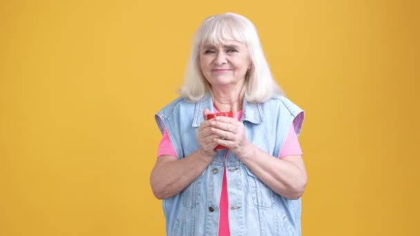 Verouderde dame koud drinken warme drank medische thee geïsoleerde heldere kleur achtergrond — Stockvideo