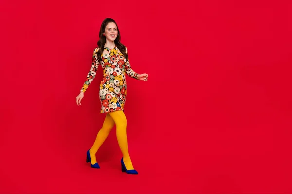 Full längd kroppsstorlek bild av attraktiv glad flicka promenader kopiera utrymme gott humör isolerad över klarröd färg bakgrund — Stockfoto