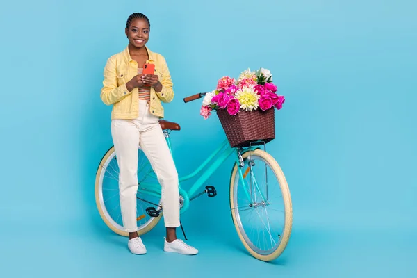 Full length body size view of beautiful trendy cheery girl riding bike using device chat isolated on bright blue color background — 스톡 사진