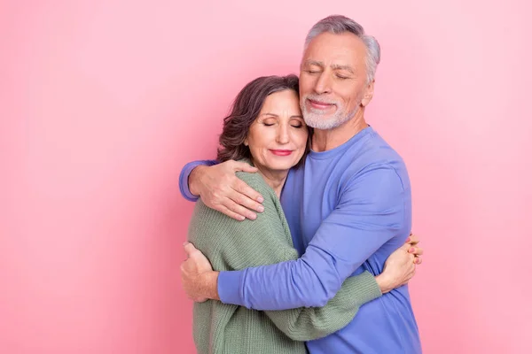 Portrait of two handsome beautiful sweet kind affectionate people cuddling isolated over pink pastel color background —  Fotos de Stock