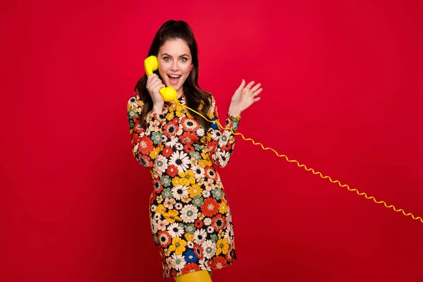 Portrait of beautiful trendy girly girl talking on phone land line discussing news isolated over bright red color background — Stockfoto