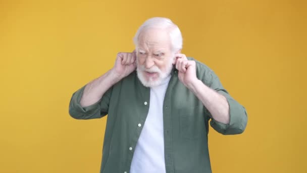 Aged man irritated music volume stop shhh isolated vivid color background — Stockvideo