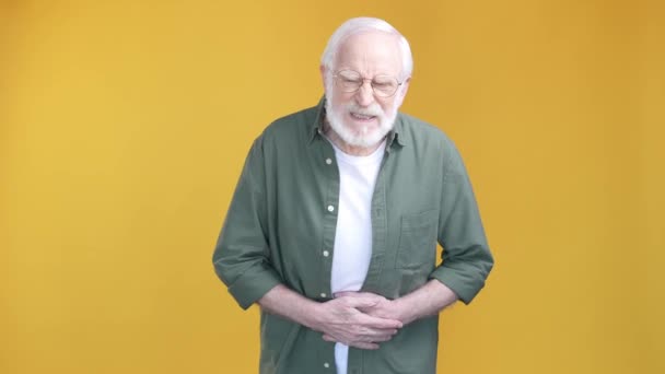 Åldrad man lider fruktansvärd smärta magen isolerad ljus färg bakgrund — Stockvideo