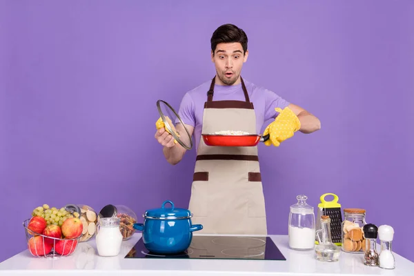 Foto de funky impressionado namorado vestido chef roupa olhando queimado jantar isolado cor roxa fundo — Fotografia de Stock