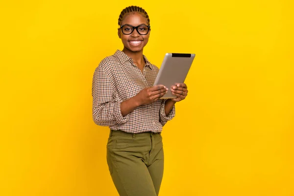 Photo of cheerful funny lady dressed checkered shirt spectacles typing modern device isolated yellow color background — Zdjęcie stockowe