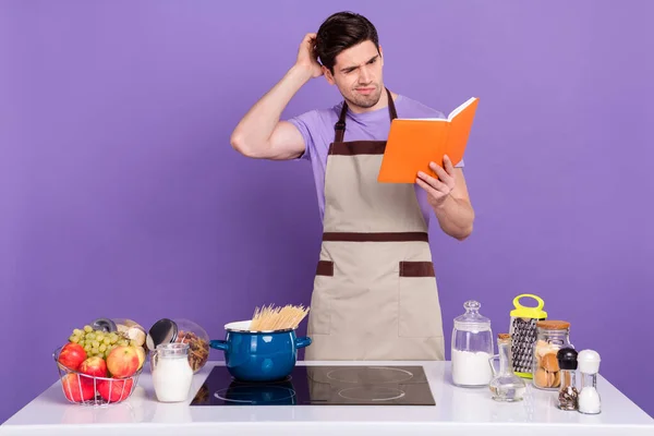 Foto do marido incerto usar aventais cinza não sei como cozinhar jantar isolado cor violeta fundo — Fotografia de Stock