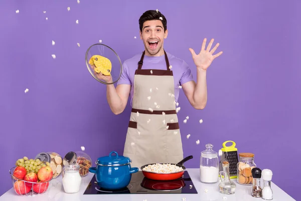 Photo of pretty shocked guy wear grey apron open frying pan pop corn explosion isolated violet color background — Foto Stock