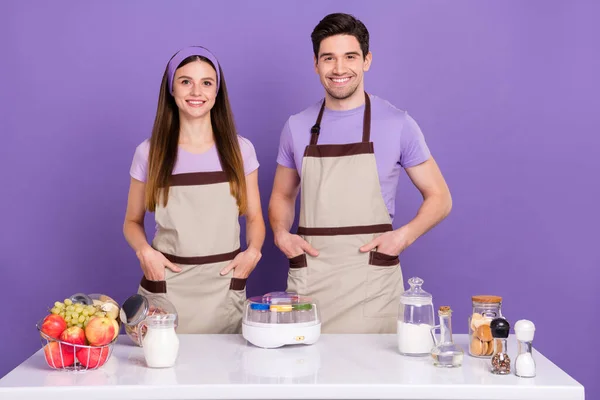 Photo of confident cheerful husband wife wear grey aprons cooking domestic dairy isolated violet color background — ストック写真