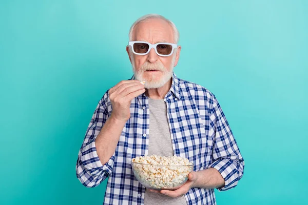 Photo of serious pensioner addicted to television eating popcorn wear checkered casual shirt isolated on teal color background — Stock Photo, Image