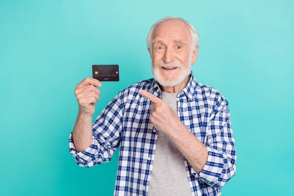 Retrato de pessoa alegre indicar dedo cartão de débito de plástico isolado no fundo cor turquesa — Fotografia de Stock