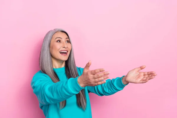 Portret van opgewonden grappige dame kijken lege ruimte handen vangen geïsoleerd op roze kleur achtergrond — Stockfoto