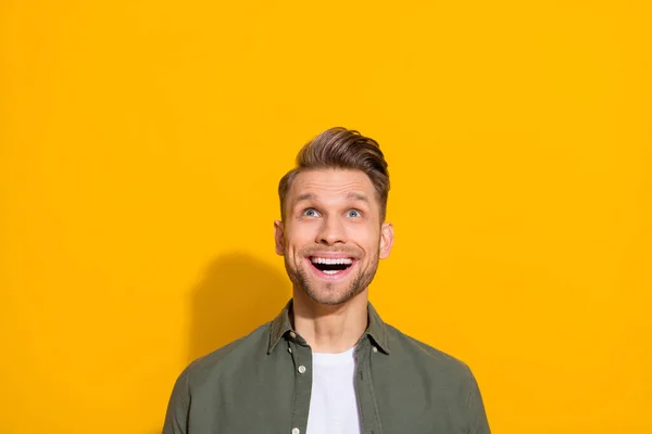 Portrait of attractive cheerful amazed blond guy looking up copy blank space isolated over bright yellow color background — Stock Fotó