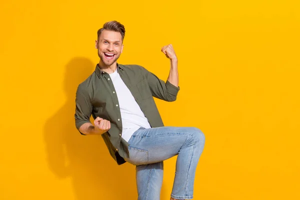 Portrait of attractive cheerful lucky guy rejoicing having fun great news isolated over bright yellow color background — Stock Fotó