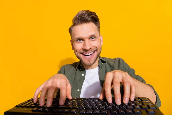 Portrait of attractive cheery guy writing text gambling having fun isolated over bright yellow color background — Stock Photo, Image