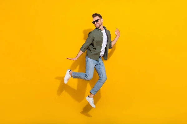 Full length body size view of attractive cheerful guy jumping having fun good mood isolated over bright yellow color background —  Fotos de Stock