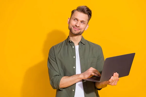 Portrait of attractive minded smart clever cheerful guy using laptop thinking copy space isolated over bright yellow color background — Stockfoto