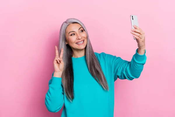 Photo of positive person make selfie hand fingers demonstrate v-sign isolated on pink color background — Stok fotoğraf