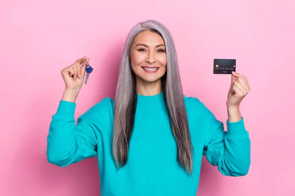 Photo of positive lady show debit plastic card key toothy smile isolated on pink color background — Foto Stock