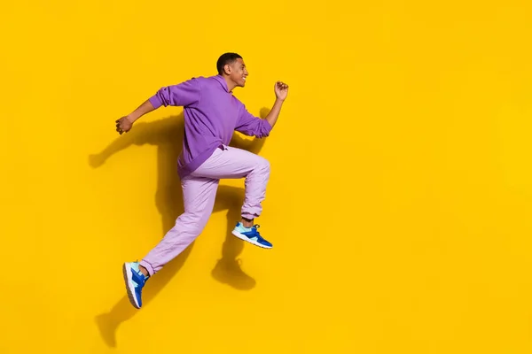 Full length body size view of handsome trendy cheerful guy jumping running advert isolated on vivid yellow color background — Stockfoto