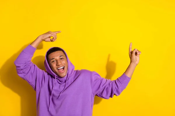 Photo of handsome guy presenting promotional advert wear comfy soft hoodie isolated on yellow color background — ストック写真