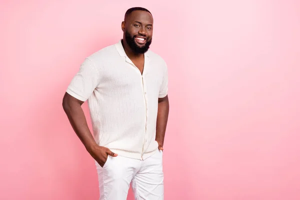 Photo of charming confident young man wear white shirt smiling arms pockets empty space isolated pink color background — Stockfoto