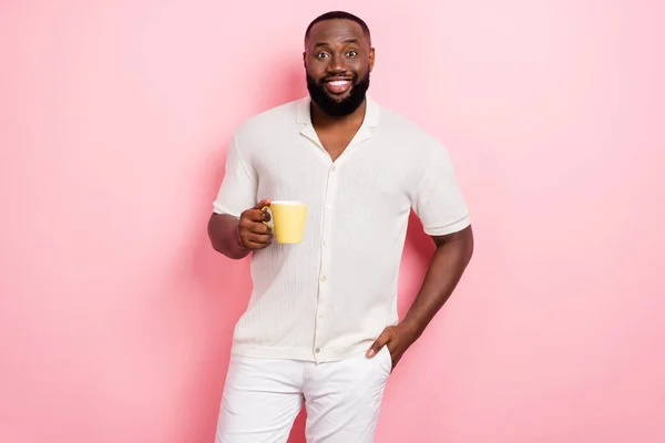 Foto van vrij charmante man gekleed wit shirt glimlachen genieten van smakelijke koffie geïsoleerde roze kleur achtergrond — Stockfoto