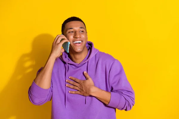 Portrait of attractive cheerful guy talking on device gadget discussing isolated over vibrant yellow color background —  Fotos de Stock