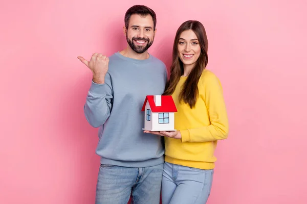 Portrait of beautiful handsome friends friendship holding new home copy space ad isolated over pink pastel color background — Φωτογραφία Αρχείου