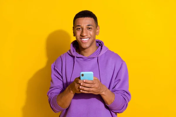 Portrait of attractive cheerful guy using gadget post smm like app 5g isolated over bright yellow color background —  Fotos de Stock