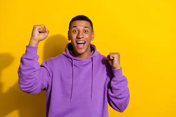 Portrait of attractive lucky cheerful guy rejoicing having fun great sport fan isolated over vivid yellow color background — Fotografia de Stock