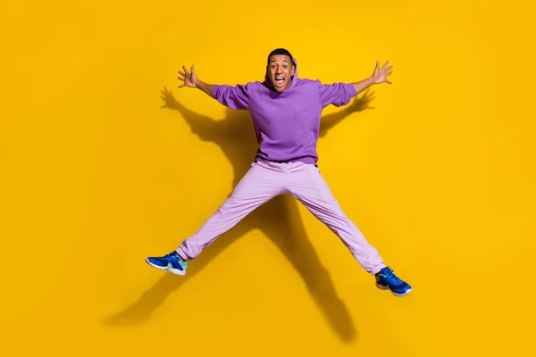Full length body size view of handsome trendy overjoyed guy jumping having fun isolated on bright yellow color background — Zdjęcie stockowe
