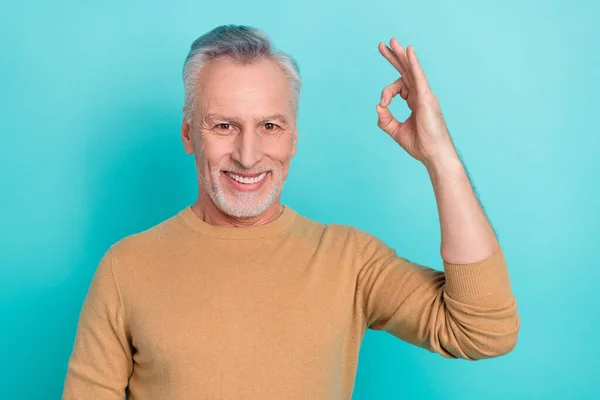 Portret van knappe vrolijke man arm vingers demonstreren okey symbool geïsoleerd op turquoise kleur achtergrond — Stockfoto