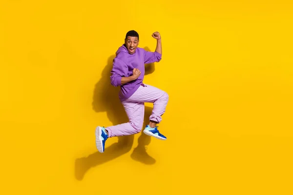 Full length body size view of handsome trendy overjoyed cheerful guy jumping great luck isolated on vivid yellow color background —  Fotos de Stock