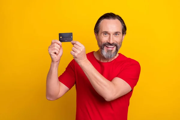 Photo of funky young brunet man hold card wear isolated on yellow color background — Stok fotoğraf