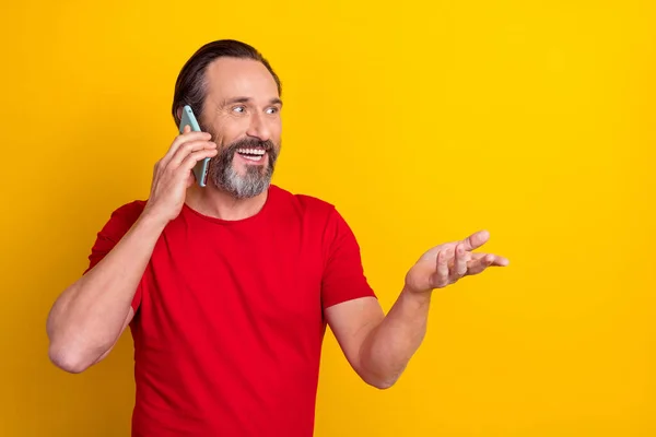 Photo of funny mature brunet man say telephone wear red t-shirt isolated on yellow color background — 图库照片