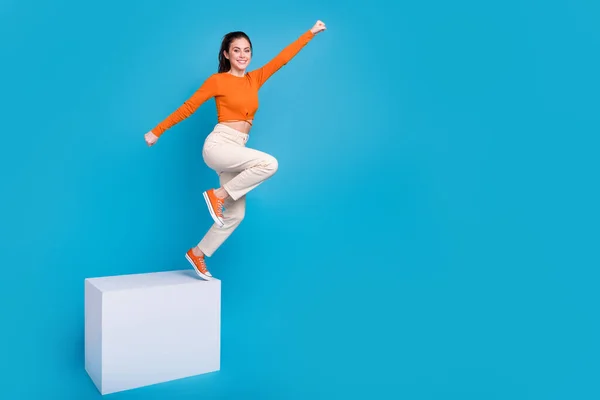 Full length photo of cheerful good mood active energetic girl flying jumping up isolated on blue color background — Stock Fotó