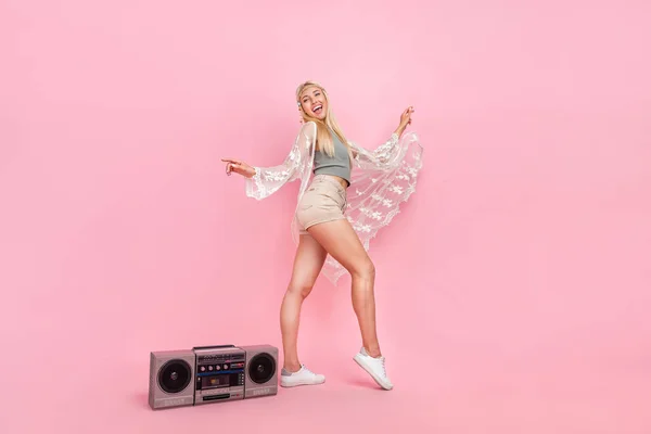 Full size photo of young blond lady dance near boombox wear top cape shorts footwear isolated on pink background — Fotografia de Stock