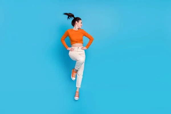 Фото активної енергійної позитивної дівчини, що стрибає вгору, весело ізольовані на синьому кольорі — стокове фото