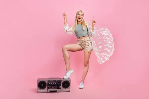 Full length photo of young blond lady index up with boombox wear top cape shorts shoes isolated on pink background — Fotografia de Stock