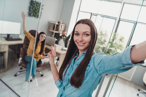 Photo of three corporate partners make selfie hand fingers demonstrate v-sign workstation indoors — Foto Stock