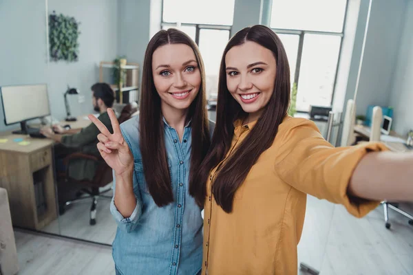 Portretul a două fete frumoase vesele experți prieteni care arată v-semn distractiv bună dispoziție la locul de muncă stație de lucru în interior — Fotografie, imagine de stoc