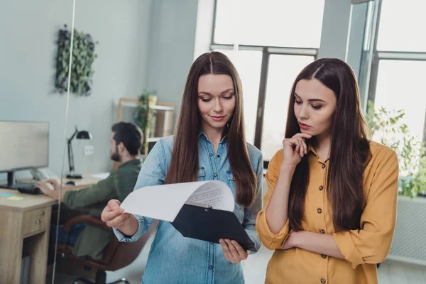 Portrait of two attractive skilled focused people experts discussing marketing plan strategy reading list at work place station indoors — Foto Stock