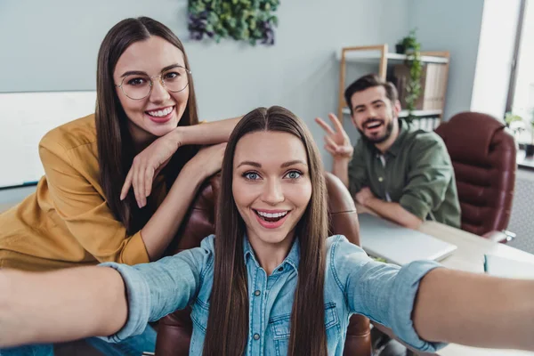 Photo of three business partners take selfie hand demonstrate v-sign meeting workstation indoors — Photo