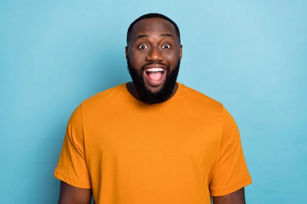 Photo of funky excited guy wear orange t-shirt smiling open mouth isolated blue color background — Stockfoto