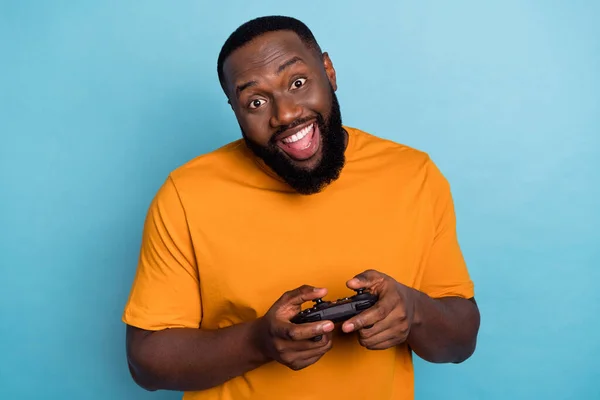 Retrato de chico barbudo divertido alegre atractivo jugando juego en red que se divierte aislado sobre fondo de color azul brillante —  Fotos de Stock