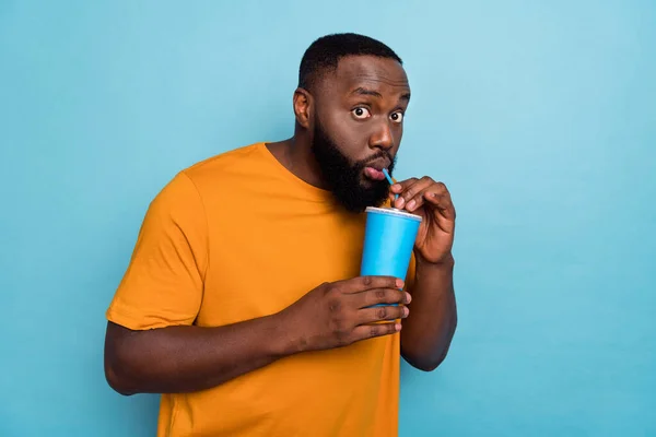 Portrait of attractive funny amazed guy drinking soda free spare time isolated over bright blue color background — Stockfoto
