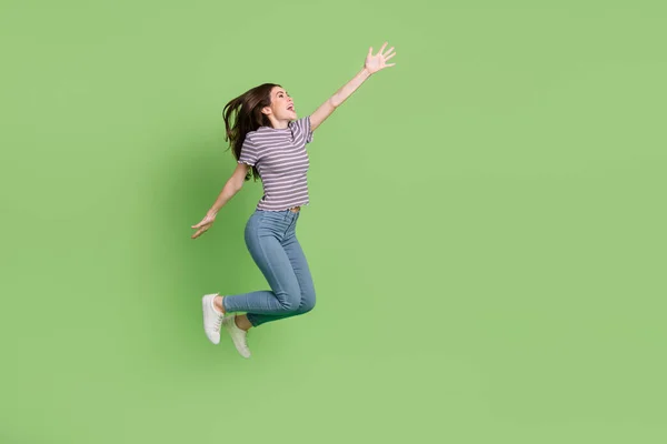 Tamanho do corpo de comprimento total vista de atraente alegre sorte motivado menina pulando espaço de cópia isolado no fundo de cor verde brilhante — Fotografia de Stock