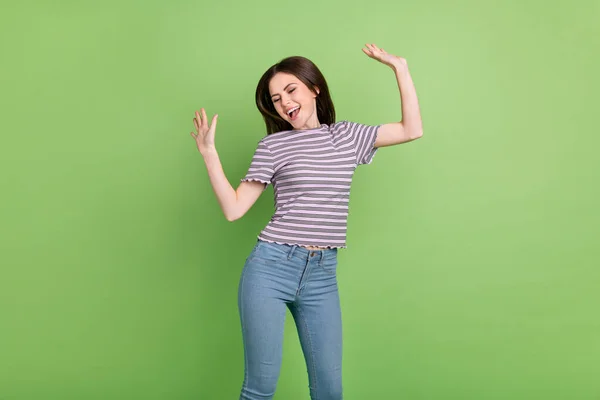 Retrato de menina alegre atraente de cabelos castanhos dançando se divertindo pulando bom humor isolado sobre fundo de cor verde brilhante — Fotografia de Stock