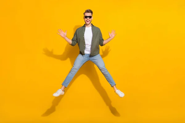 Full length body size view of attractive cheerful crazy overjoyed guy jumping having fun isolated over shine yellow color background — 图库照片